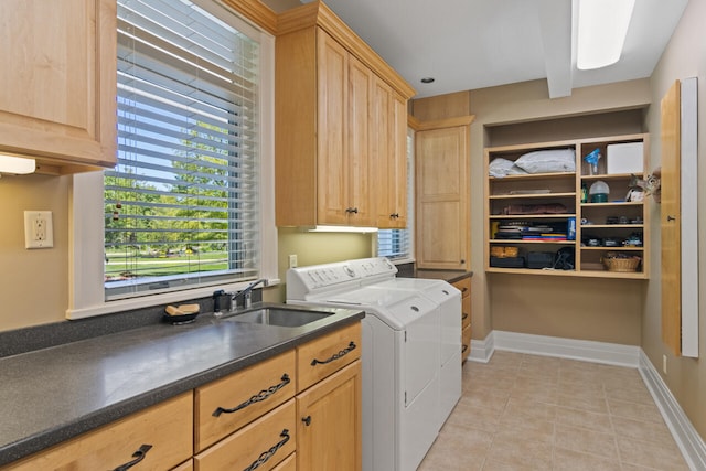 laundry area featuring sink, washer and clothes dryer, cabinets, and light tile patterned flooring