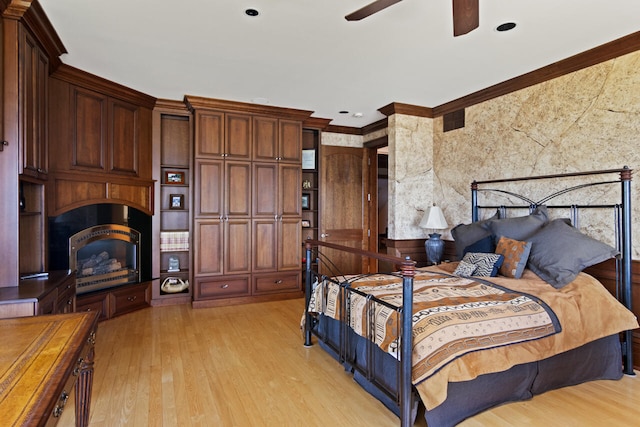 bedroom with crown molding, light hardwood / wood-style floors, and ceiling fan