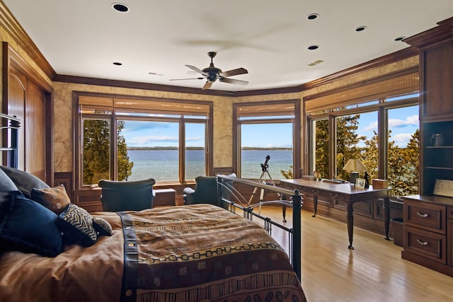 bedroom with a water view, ceiling fan, crown molding, and light wood-type flooring