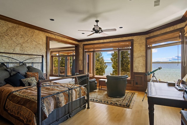 bedroom with crown molding, a water view, wood-type flooring, and ceiling fan