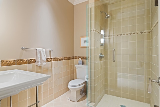 bathroom featuring tile walls, toilet, tile patterned flooring, walk in shower, and crown molding