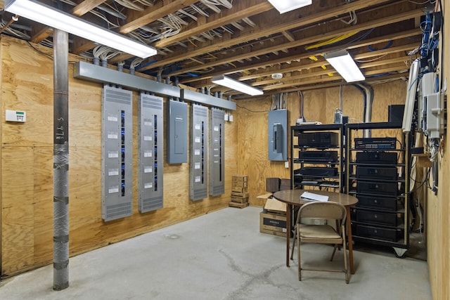 basement with electric panel and wooden walls