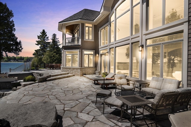 patio terrace at dusk with an outdoor hangout area and a balcony