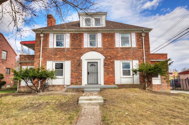 colonial inspired home featuring a front lawn