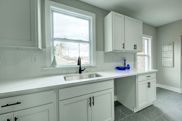 kitchen featuring a healthy amount of sunlight, white cabinets, and sink