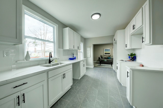 kitchen with backsplash, sink, tile floors, and white cabinets