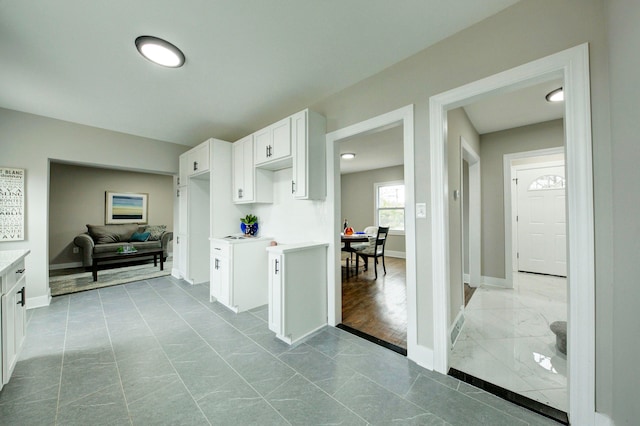 kitchen with tile floors and white cabinetry