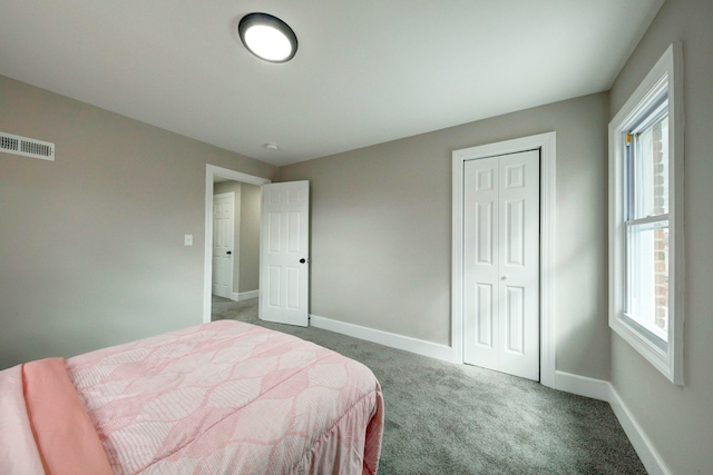 bedroom featuring dark colored carpet and a closet