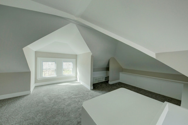 bonus room with vaulted ceiling and carpet