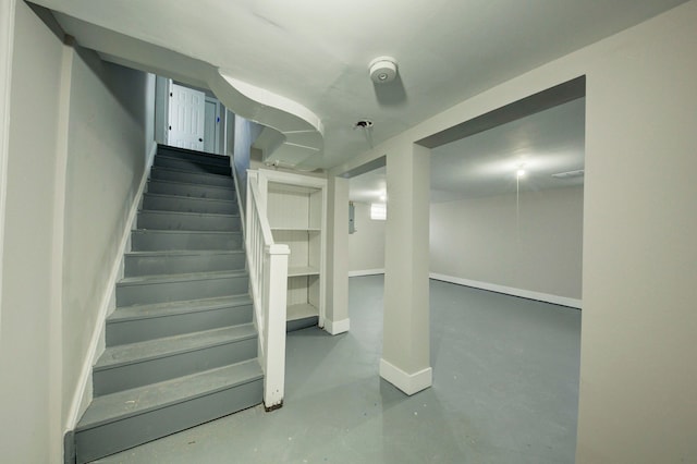 staircase featuring concrete flooring