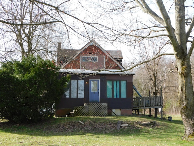 view of front of home featuring a front lawn and a wooden deck