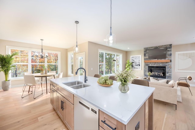 kitchen featuring sink, dishwasher, an island with sink, a wealth of natural light, and pendant lighting