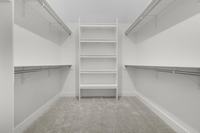 walk in closet featuring light colored carpet