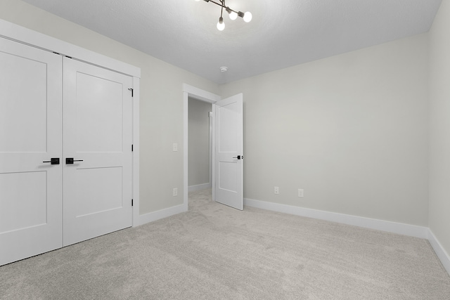 unfurnished bedroom featuring a closet and light colored carpet