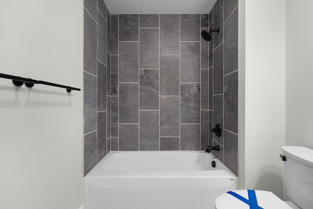 bathroom featuring tiled shower / bath and toilet