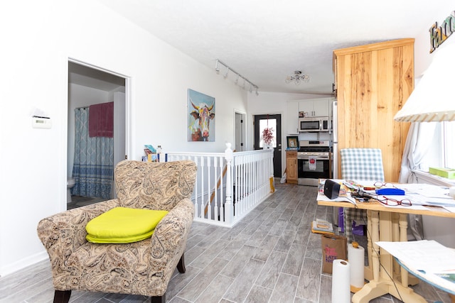 interior space with light hardwood / wood-style floors and track lighting