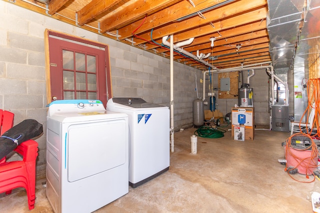 clothes washing area featuring electric water heater and washer and dryer