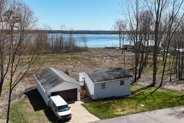 exterior space with an outdoor structure, a water view, and a garage