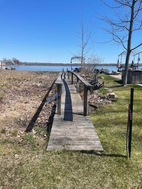 dock area featuring a water view and a lawn