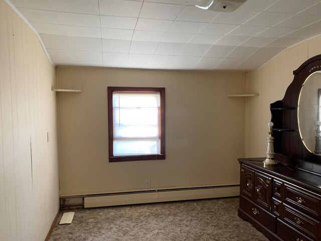 unfurnished bedroom with baseboard heating and light carpet