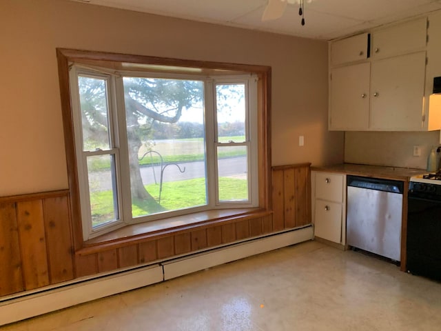 kitchen featuring stainless steel dishwasher, a baseboard heating unit, white cabinets, and a wealth of natural light