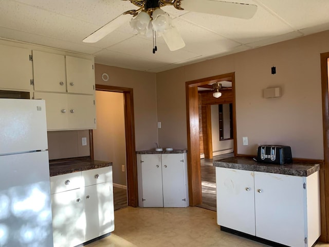 kitchen featuring white fridge, ceiling fan, light wood-type flooring, and white cabinetry