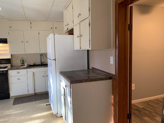 kitchen with white appliances, light hardwood / wood-style floors, extractor fan, white cabinets, and sink