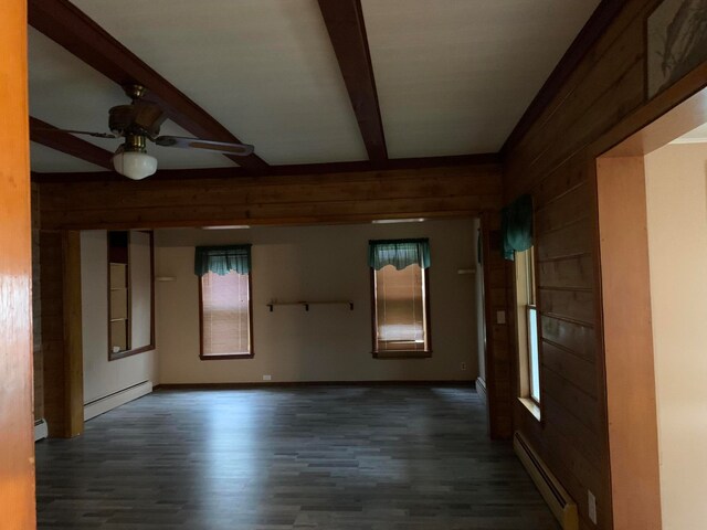 unfurnished room featuring beam ceiling, a baseboard heating unit, and dark hardwood / wood-style floors