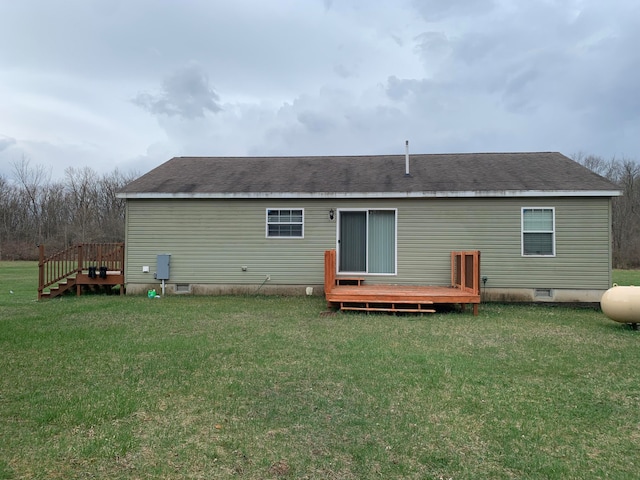 back of property with a deck and a lawn