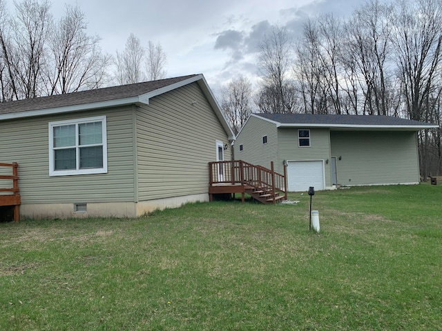 rear view of house with a garage and a yard