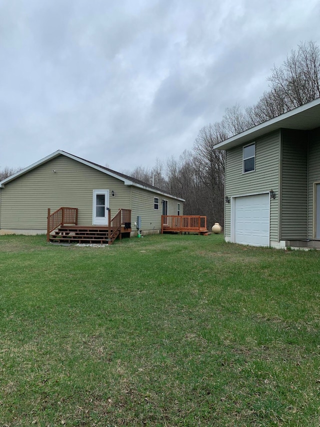 view of yard with a garage and a deck