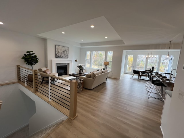 living room with a notable chandelier and light hardwood / wood-style flooring