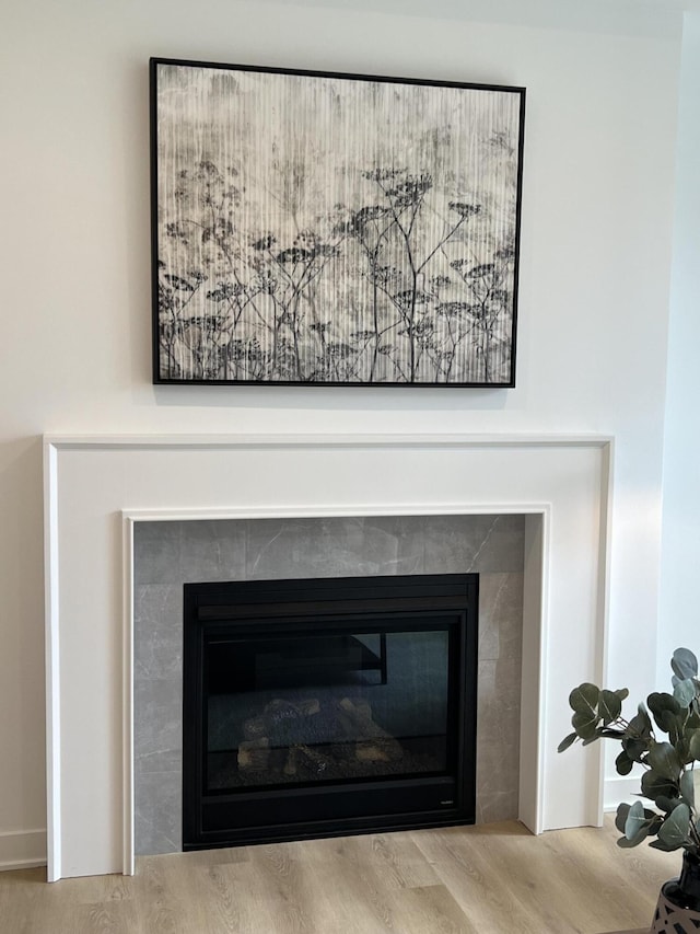 room details featuring a tile fireplace and hardwood / wood-style floors