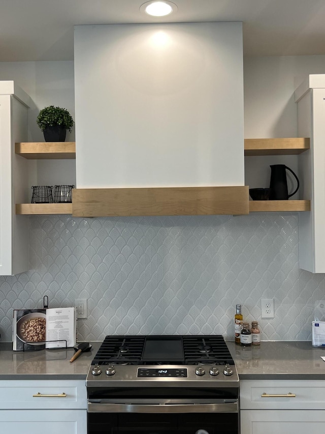 kitchen featuring tasteful backsplash, white cabinetry, and stainless steel gas range