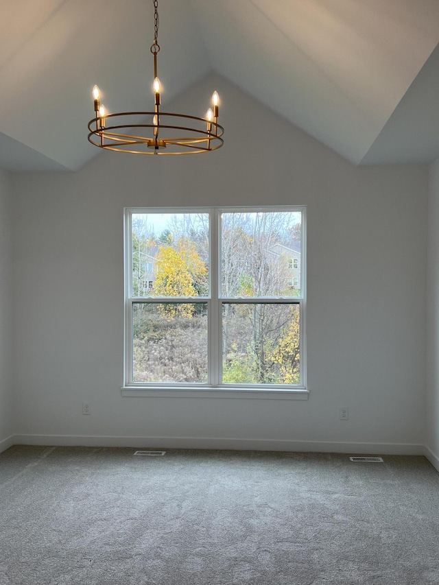 spare room featuring a chandelier, lofted ceiling, carpet flooring, and a healthy amount of sunlight