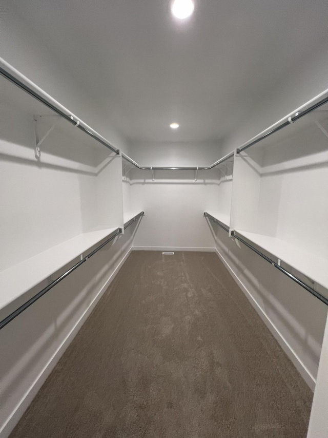 spacious closet featuring dark colored carpet