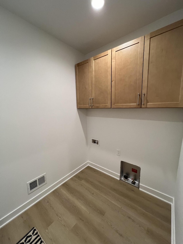 laundry room with cabinets, hardwood / wood-style floors, and washer hookup