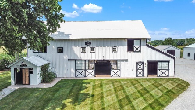 back of house with a yard and an outdoor structure