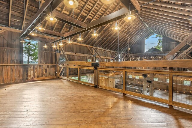 interior space featuring wood ceiling, wooden walls, hardwood / wood-style floors, and lofted ceiling with beams