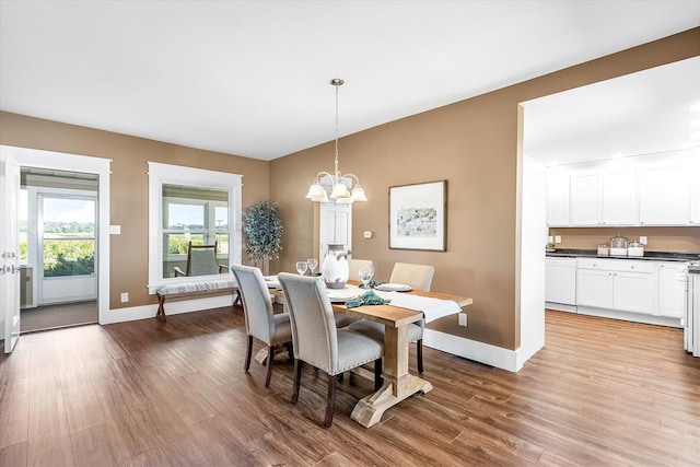 dining area with wood-type flooring and a notable chandelier