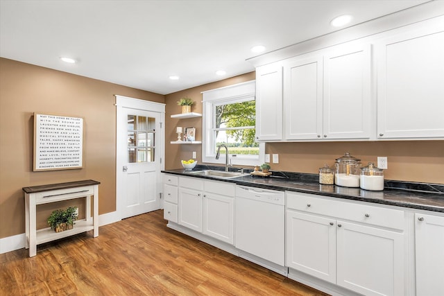 kitchen with white dishwasher, white cabinetry, sink, and light hardwood / wood-style flooring