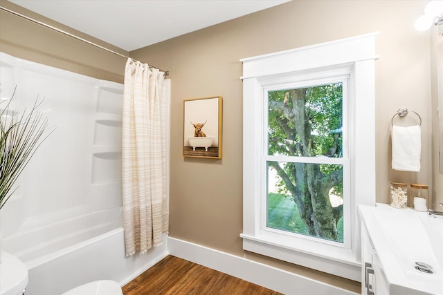 bathroom with hardwood / wood-style flooring, toilet, and shower / bath combo with shower curtain