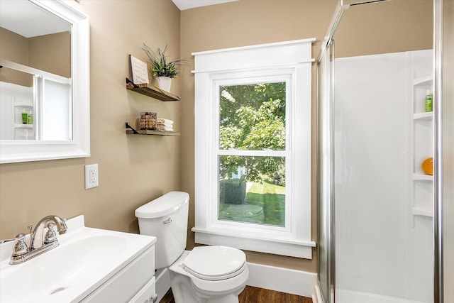 bathroom featuring toilet, vanity, hardwood / wood-style floors, and walk in shower