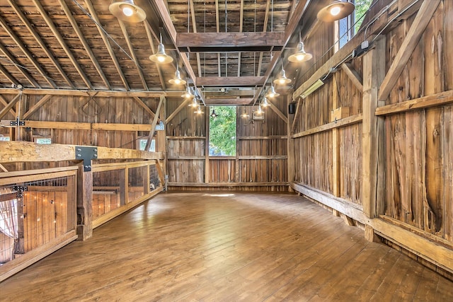 misc room with lofted ceiling with beams, wood walls, wood ceiling, and wood-type flooring