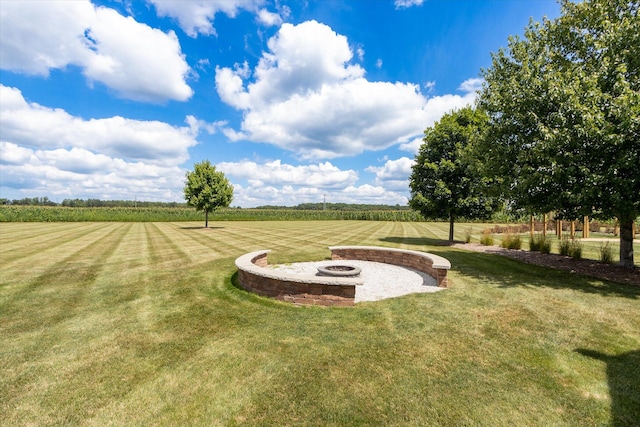 view of yard featuring a rural view and an outdoor fire pit