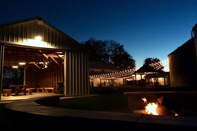 yard at dusk featuring an outdoor fire pit