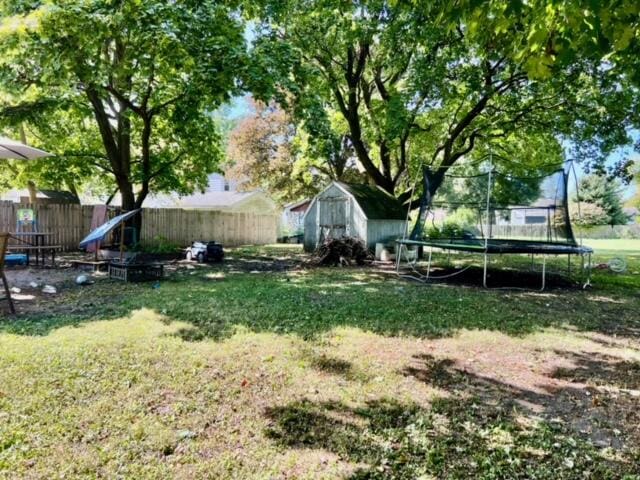 view of yard with a storage shed and a trampoline