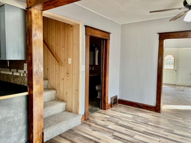 staircase with hardwood / wood-style flooring and ceiling fan