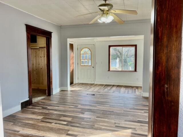 entrance foyer featuring hardwood / wood-style floors, ceiling fan, and ornamental molding