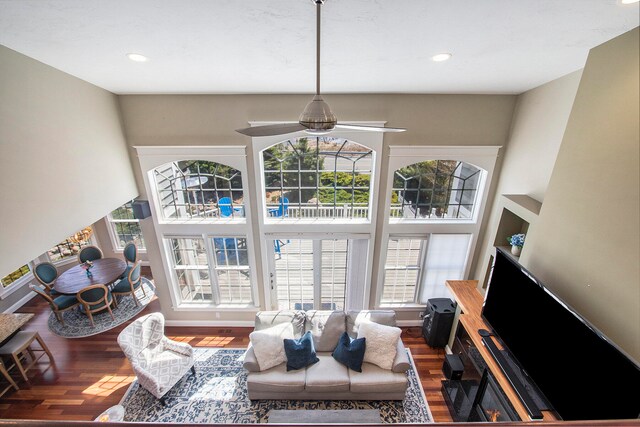 living room featuring a high ceiling, ceiling fan, and dark hardwood / wood-style floors